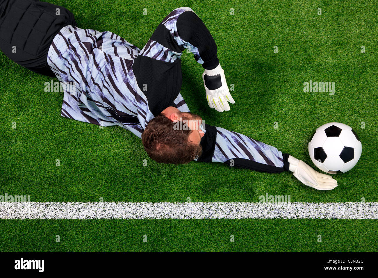Obenliegende Foto ein Fußball-Torwart, Tauchen, um den Ball vor Überschreiten der Torlinie retten. Stockfoto
