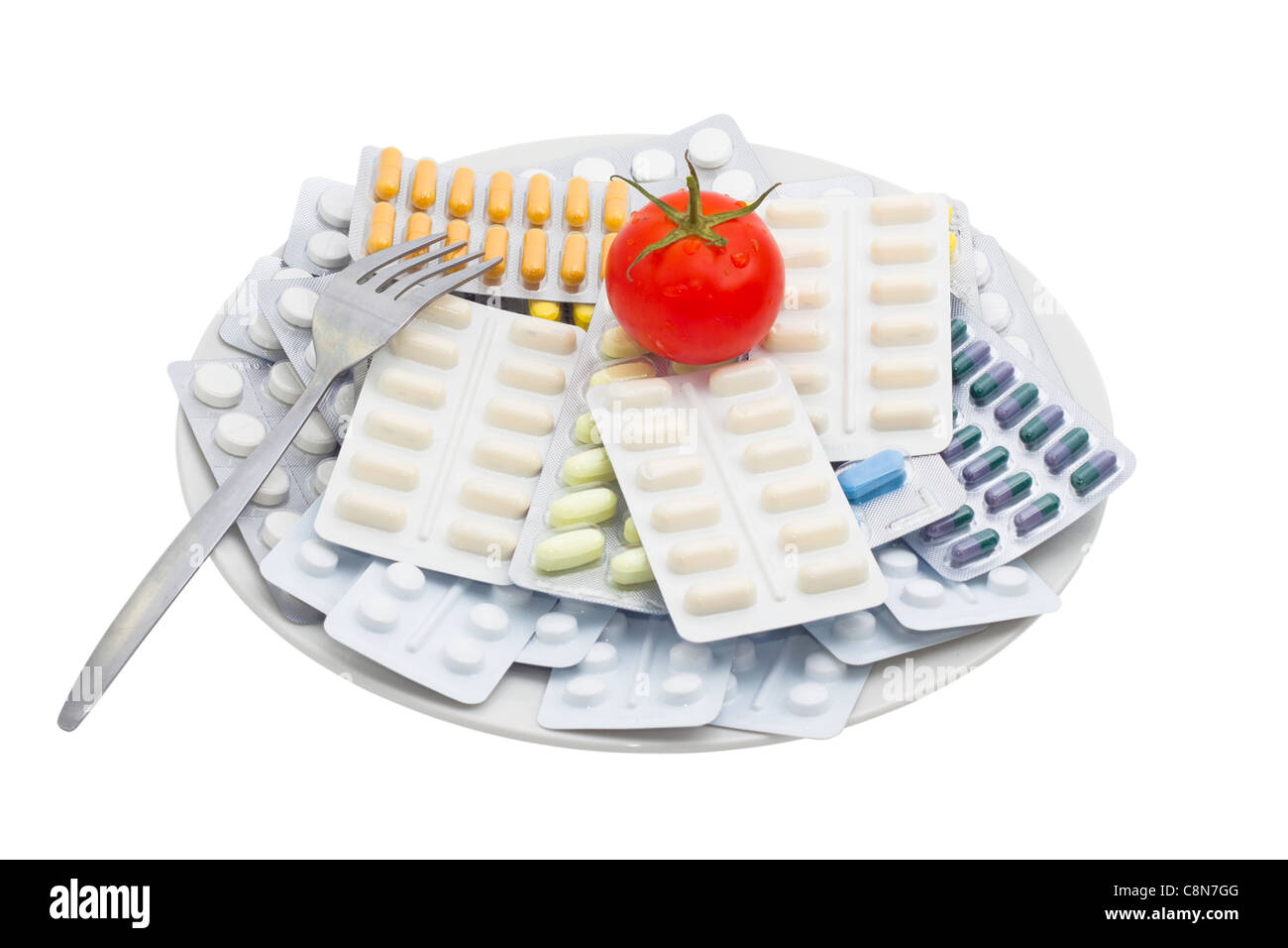 Pillen und Tabletten mit Tomaten auf Teller, isoliert auf weißem Hintergrund. Stockfoto