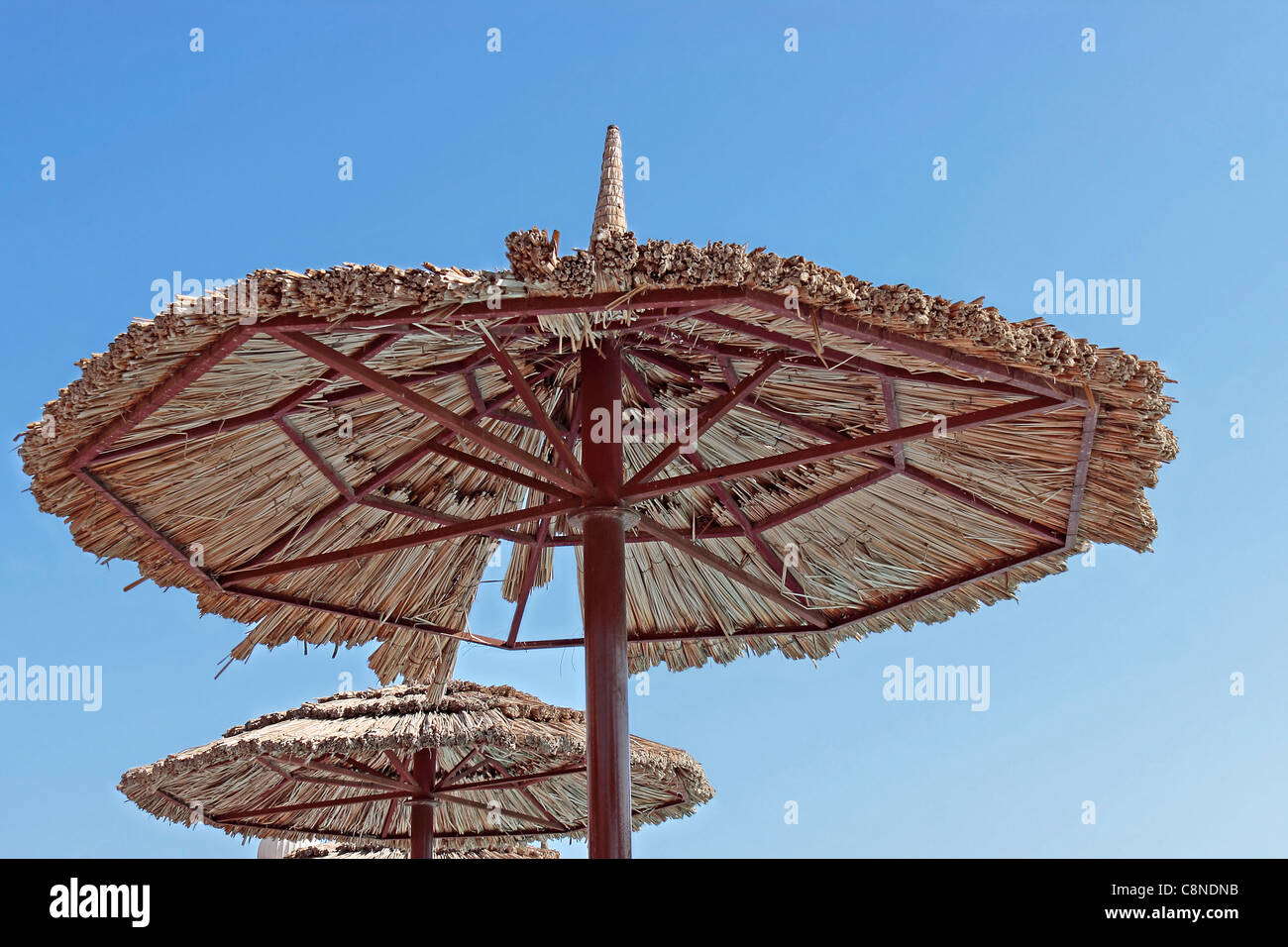 Am Pool Stahl und Reed Sonnenschirm/Sonnenschirm gegen blauen Himmel Stockfoto