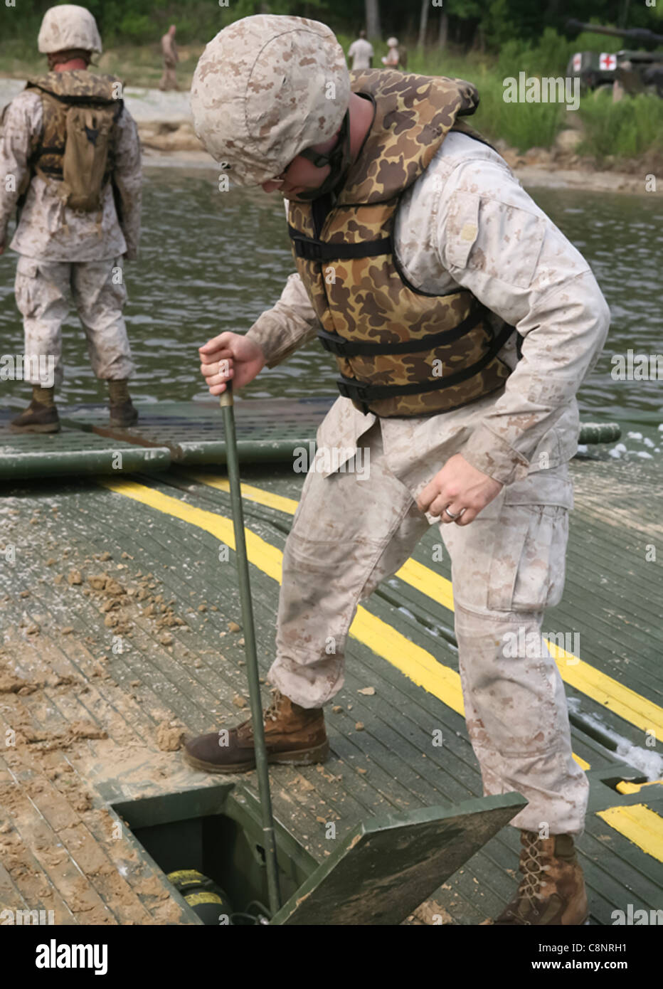 MARINE CORPS BASE CAMP LEJEUNE, N.C. - Sgt. Joshua L. Currie, eine Bekämpfung der Ingenieur mit 8 Egineer Support Battalion, 2nd Marine Logistik Gruppe, nutzt eine Hydraulikpumpe die Rampe eines verbesserten Float Brücke während einer Operation an Bord Marine Corps Base Camp Lejeune Juli 14, 2011 zu führen. Ziel der Mission war 10 M1A1 Abrams Kampfpanzer und eine M88 Hercules schwere Ausrüstung Recovery Fahrzeug an den jährlichen Schießwesen Qualifikationen zur Fähre für 2. Tank Battalion, 2nd Marine Division. Stockfoto