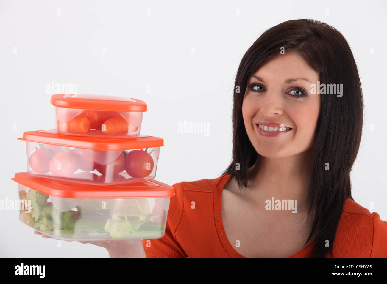 Junge Frau lächelnd mit luftdichten Boxen Stockfoto