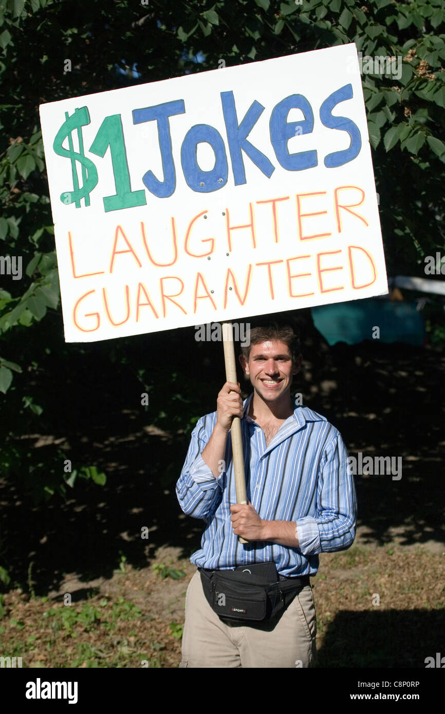 Ein Mann hält ein Schild mit Witze für einen Dollar pro Lachen während im Central Park. Stockfoto