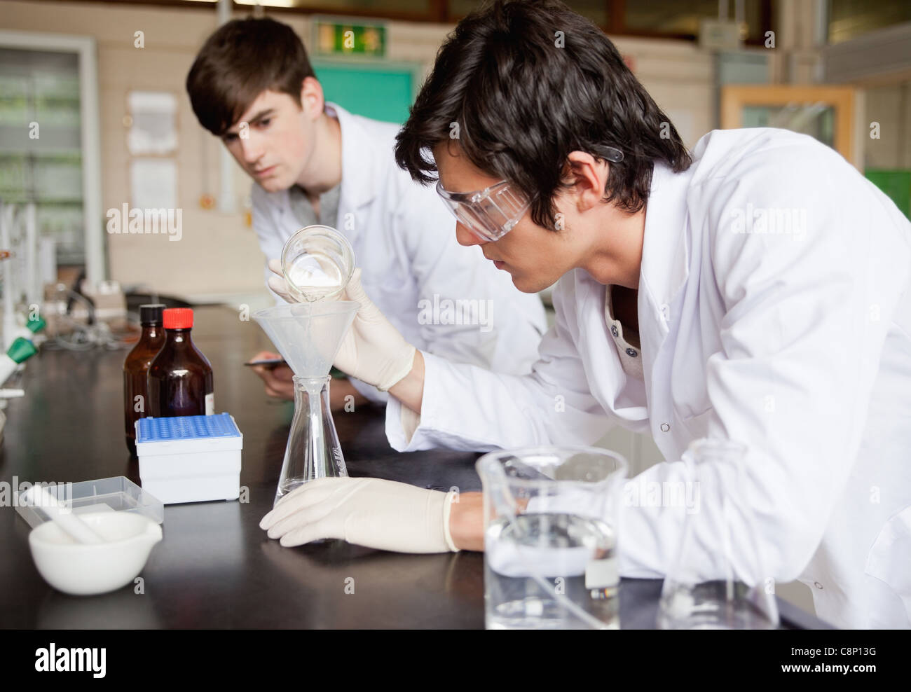 Männliche Chemiestudenten machen ein experiment Stockfoto