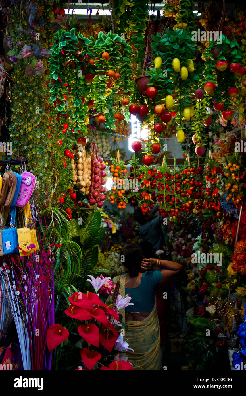 in einem beliebten Markt in in Neu-Delhi wählt eine Frau welche Kunststoff Blumen kaufen Stockfoto