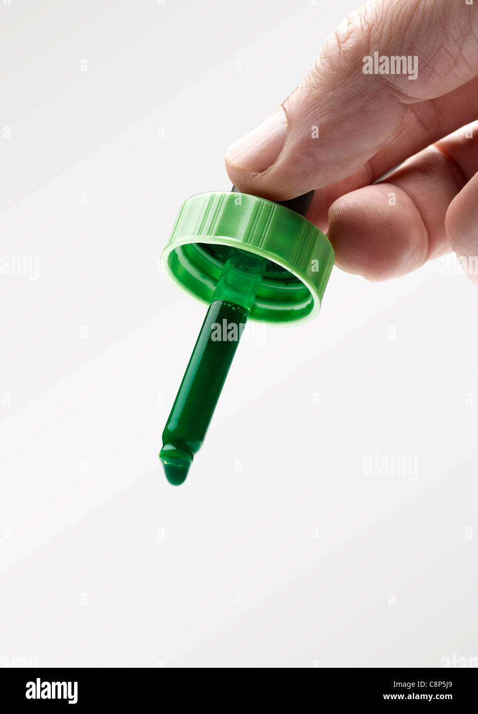 Mannes Hand hält ein Eyerdropper mit grüner Farbe (Clipping-Pfad) Stockfoto
