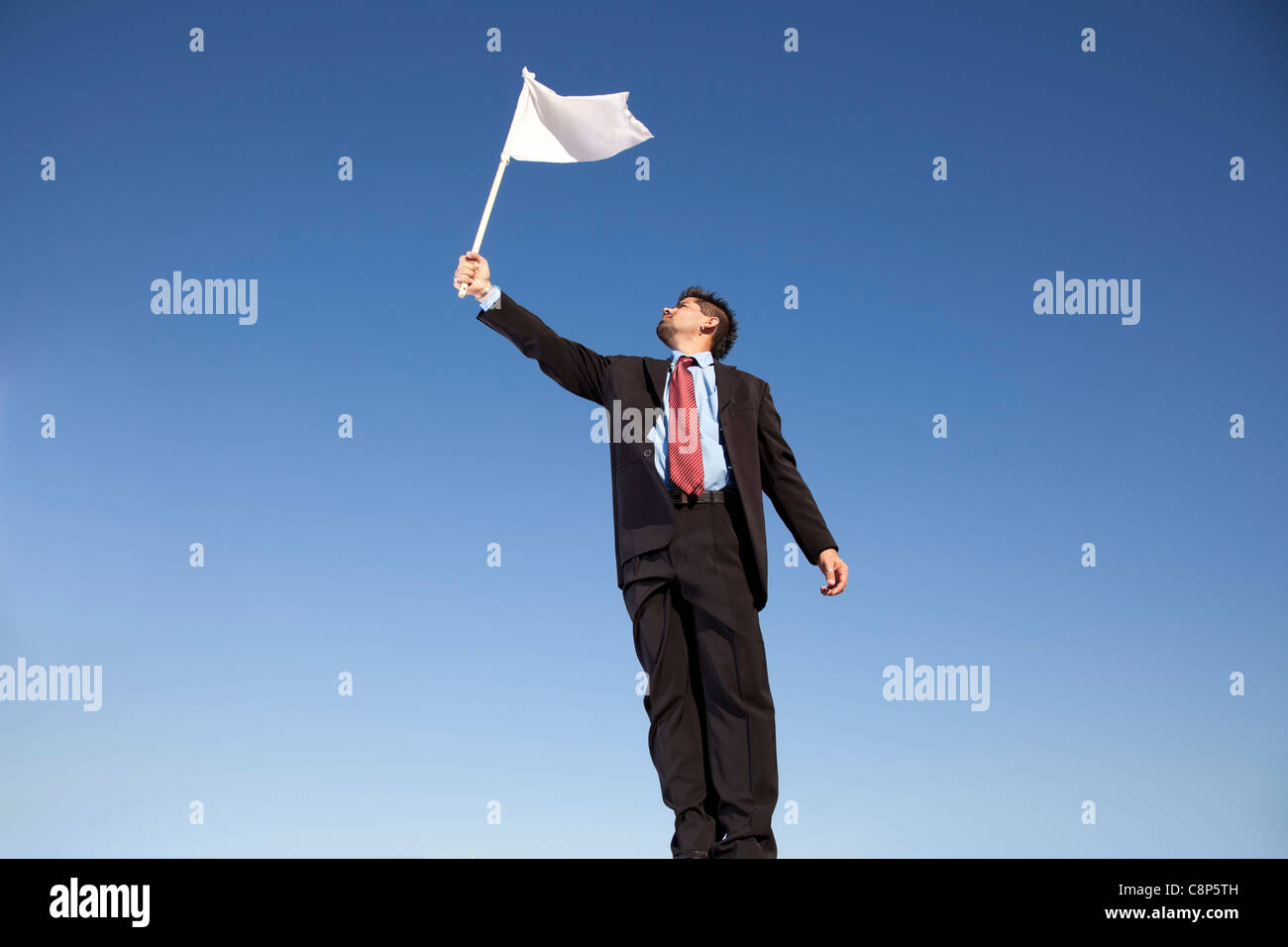 Unternehmer fordern Hingabe hält eine weiße Fahne Stockfoto