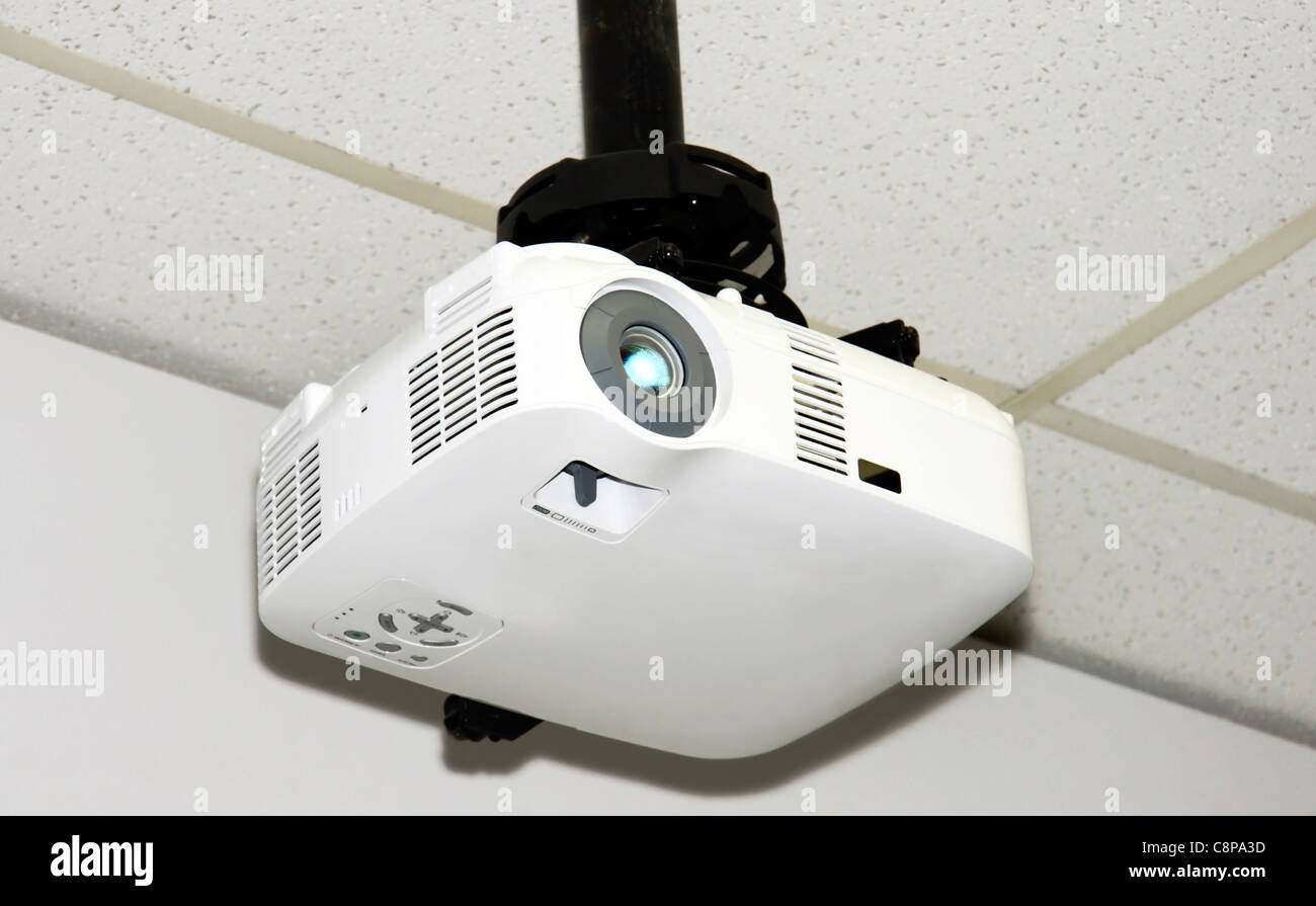 Nahaufnahme eines Multimedia-Projektors angebracht, die Akustik-Deckenplatten von einem kleinen Büro. Stockfoto