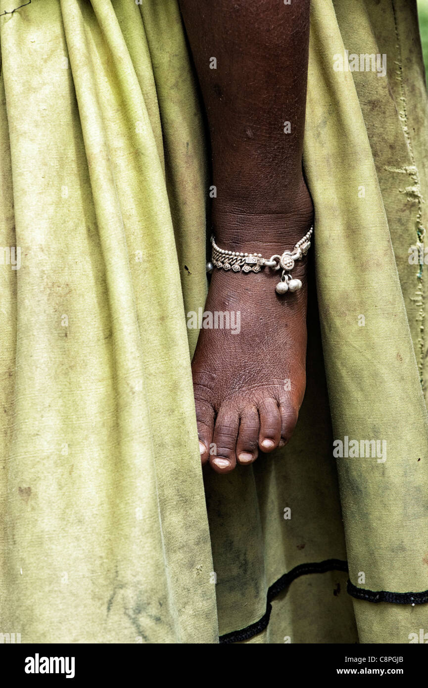 Armen indischen Babys Fuß mit Fußkettchen gegen Mütter schmutzigen Kleid abstrakt Stockfoto