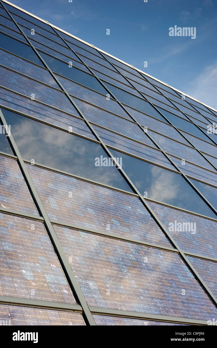 Elektrische Sonnenkollektoren montiert innerhalb einer abfallenden Glasbau Fassade. Stockfoto