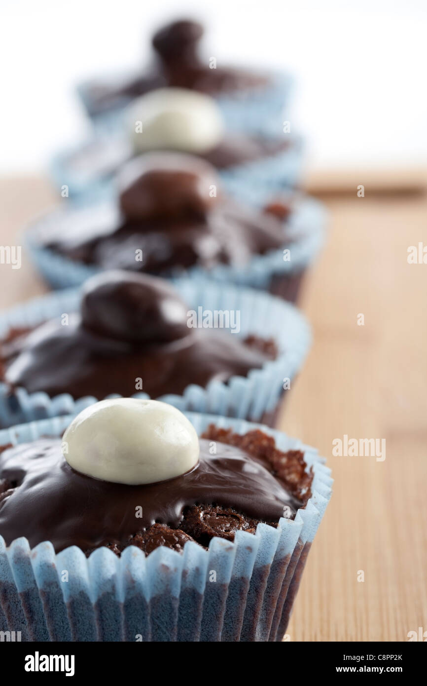Reihe von Schokoladen Cupcakes garniert mit Süßigkeiten. Stockfoto