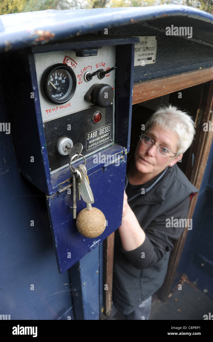 WOMAN LOOKING AT STEUERSCHALTER AUF KANAL BARGE NARROWBOAT RE BILGE PUMPE STARTER SCHALTER ZÜNDUNG CONTROL PANEL TASTEN, BATTERIE USW. Stockfoto