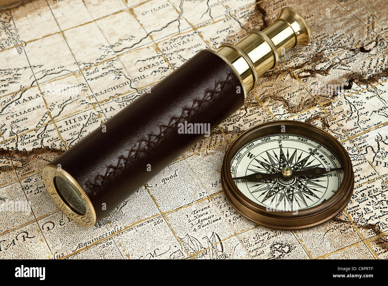 Vintage Messing Teleskop und Kompass über Antike Landkarte Stockfoto