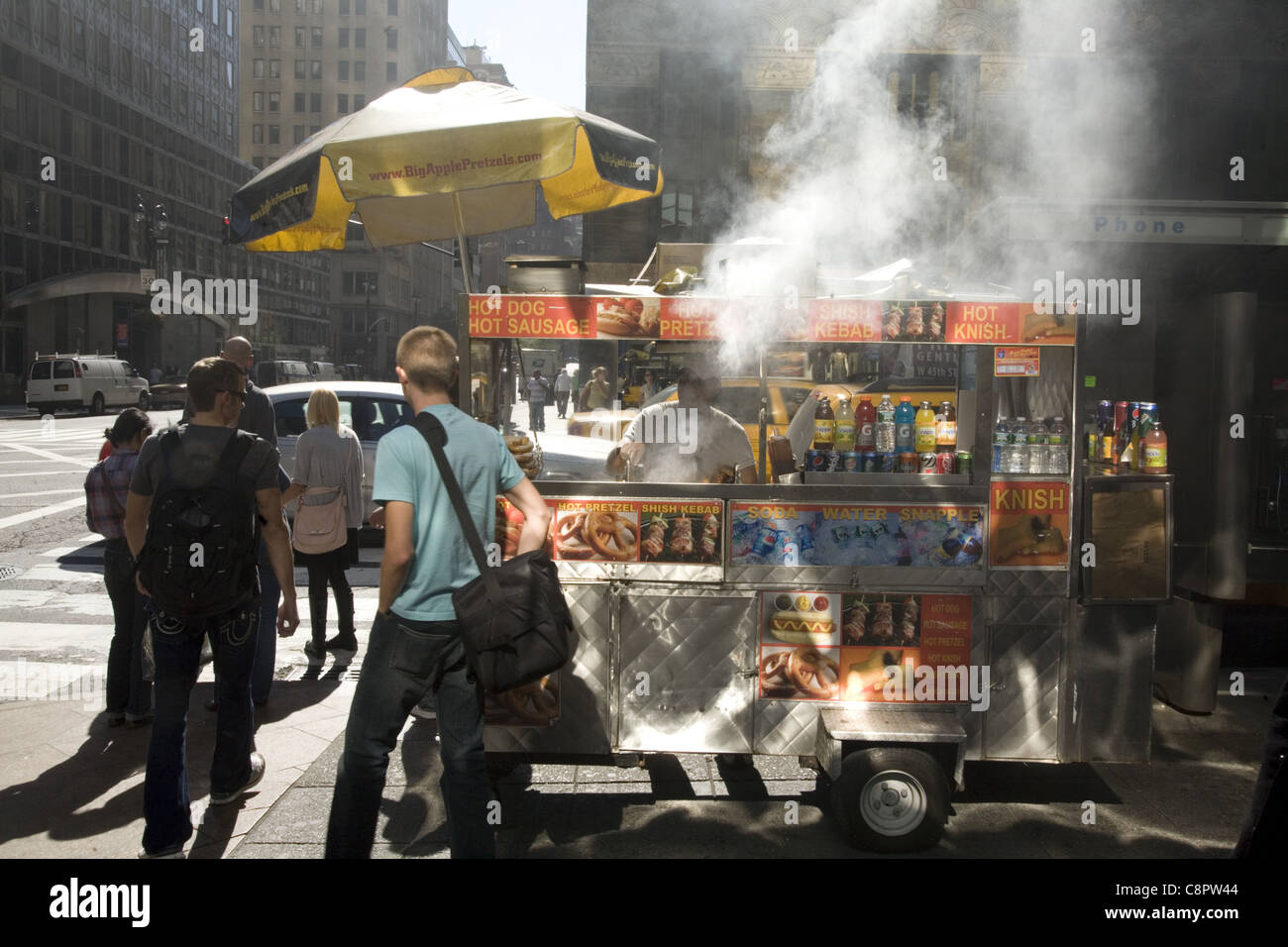 Lebensmittel-Hersteller kocht auf der Straße in Midtown Manhattan und belastet die Umwelt um ihn herum. Stockfoto