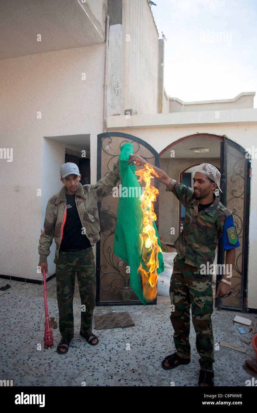 Rebell in Sirt brennen Regierung Fahnen, die sie in einem Haus von Gaddafi verwendet wird, als Versteck gefunden Stockfoto