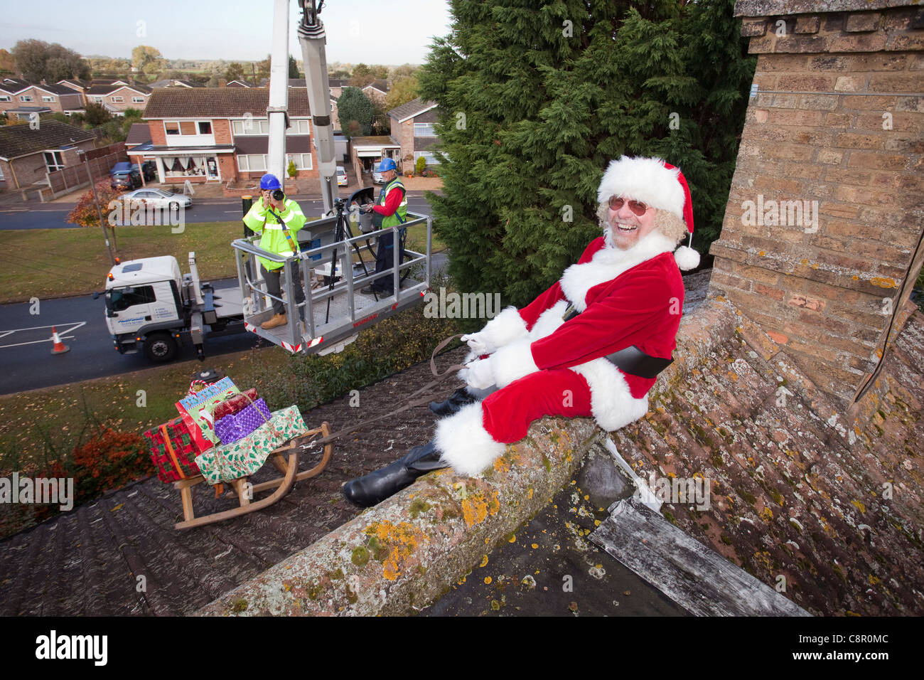 Santa Claus liefert seine Dach Top Magie mit Hilfe einer Hubarbeitsbühne UK Stockfoto