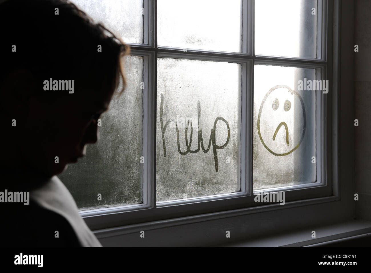 6 Jahre altes Kind schreiben Hilfe in einem Fenster in Kondenswasser Stockfoto