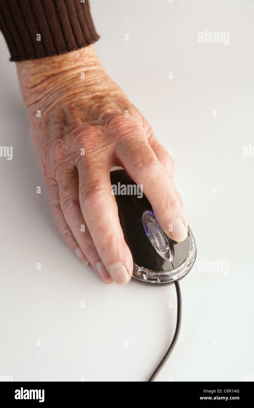 Eine alte Frau Hand mit einer Computermaus. Stockfoto