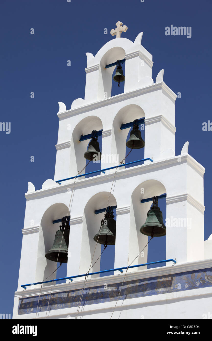 Glockenturm der Kirche gegen blauen Himmel. Oia, Santorin, Griechenland. Vertikale Zusammensetzung. Stockfoto