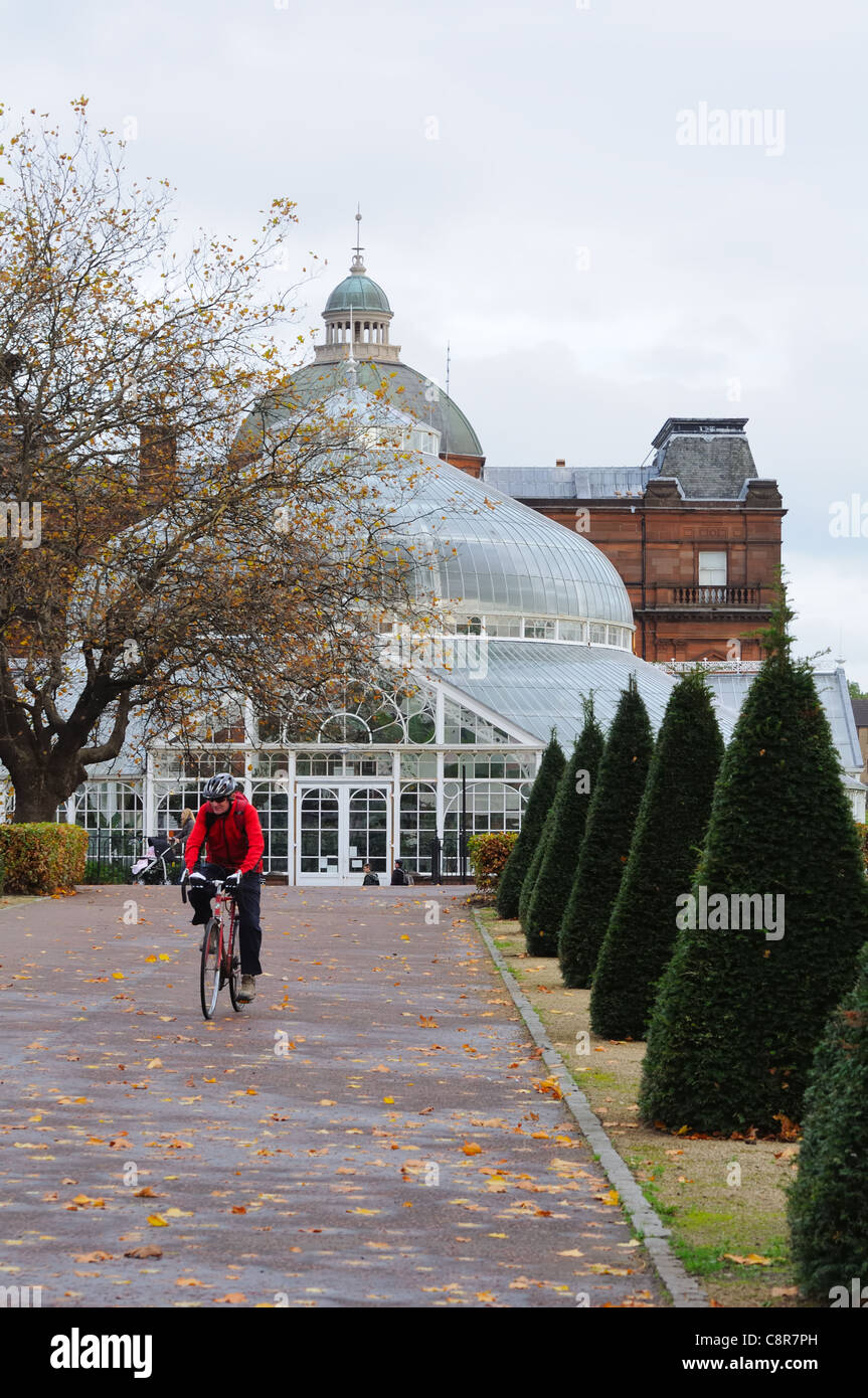 Die Winter Gardens in Glasgow Green mit Menschen und Mann auf einem Fahrrad in Glasgow, Schottland, Großbritannien, Europa. Stockfoto