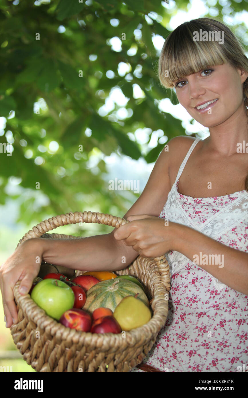 Junge Frau mit einem Korb der Frucht Stockfoto