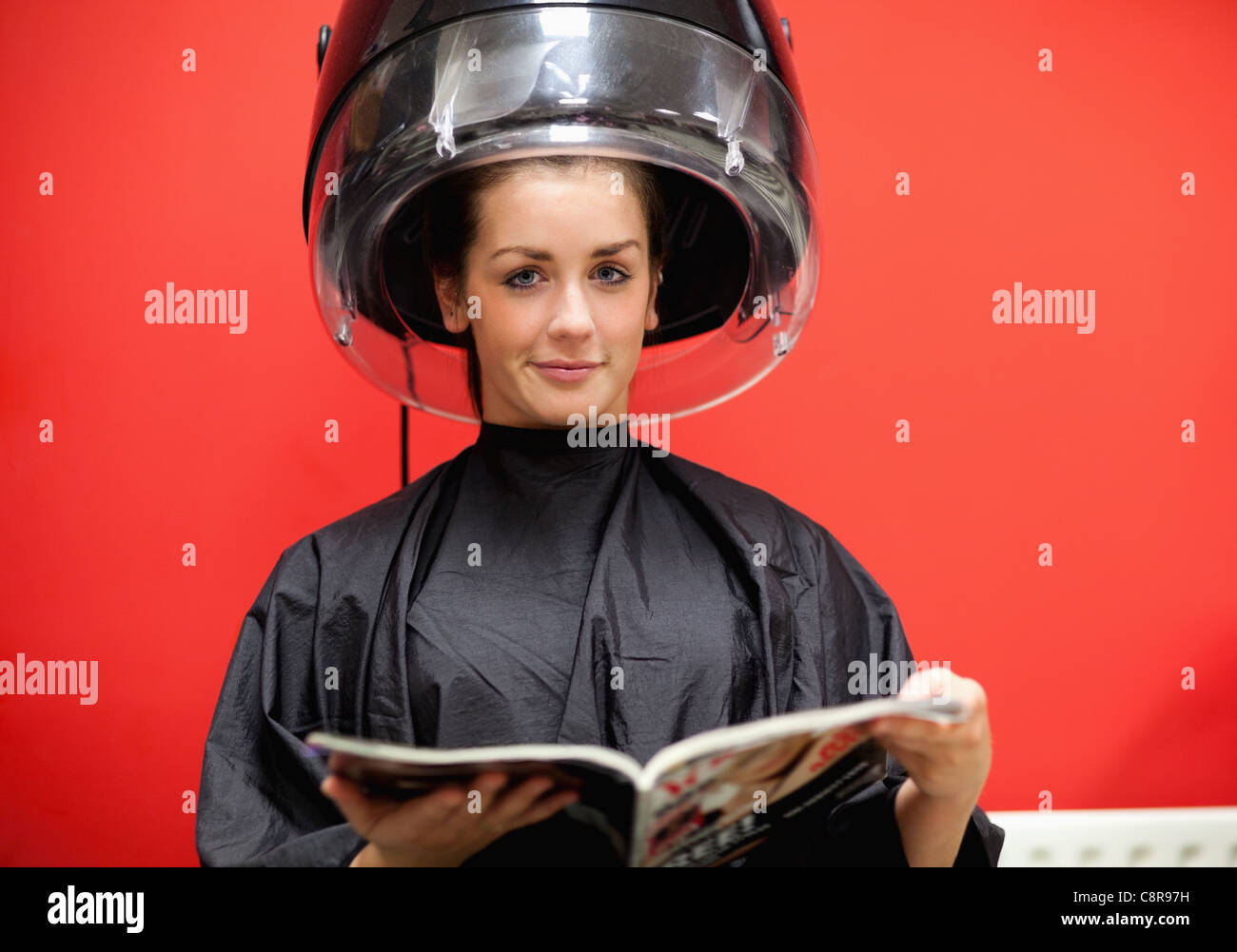 Junge Frau unter einer Friseur-Maschine Stockfoto