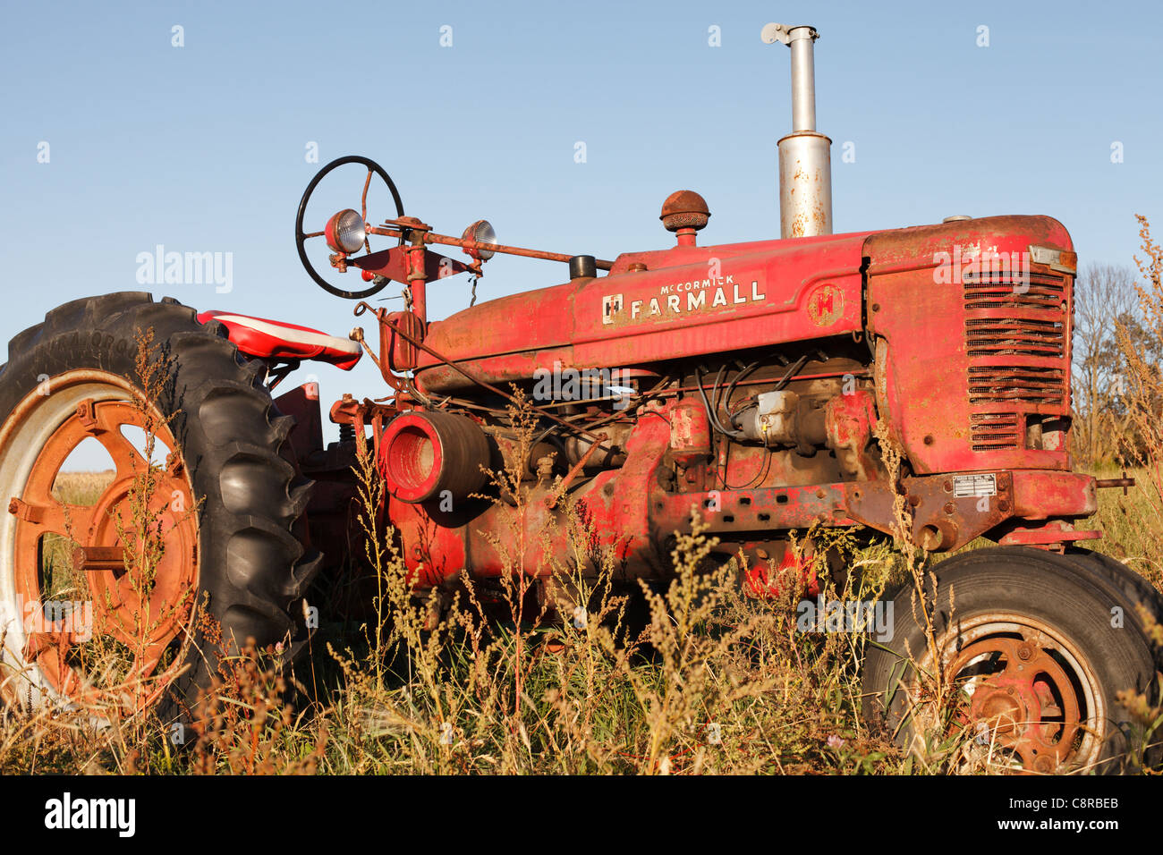 Eine alte McCormick Farmall Traktor sitzen in einem Feld. Stockfoto