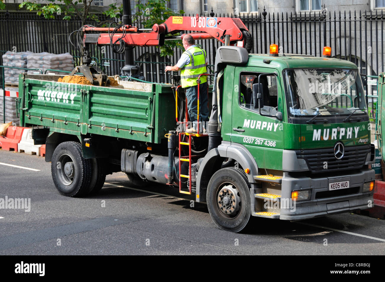 Bedienelemente für Kipperfahrzeug-Fahrer des Grabkranladers auf der Rückseite des Murphy Mercedes-Lkws mit Doppelfunktion neben Straßenbauarbeiten in London, England, Großbritannien Stockfoto