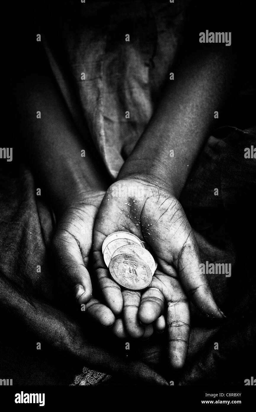 Indische Straße Mädchen betteln um Geld mit Rupie-Münzen in der Hand. Schwarz / weiß Stockfoto
