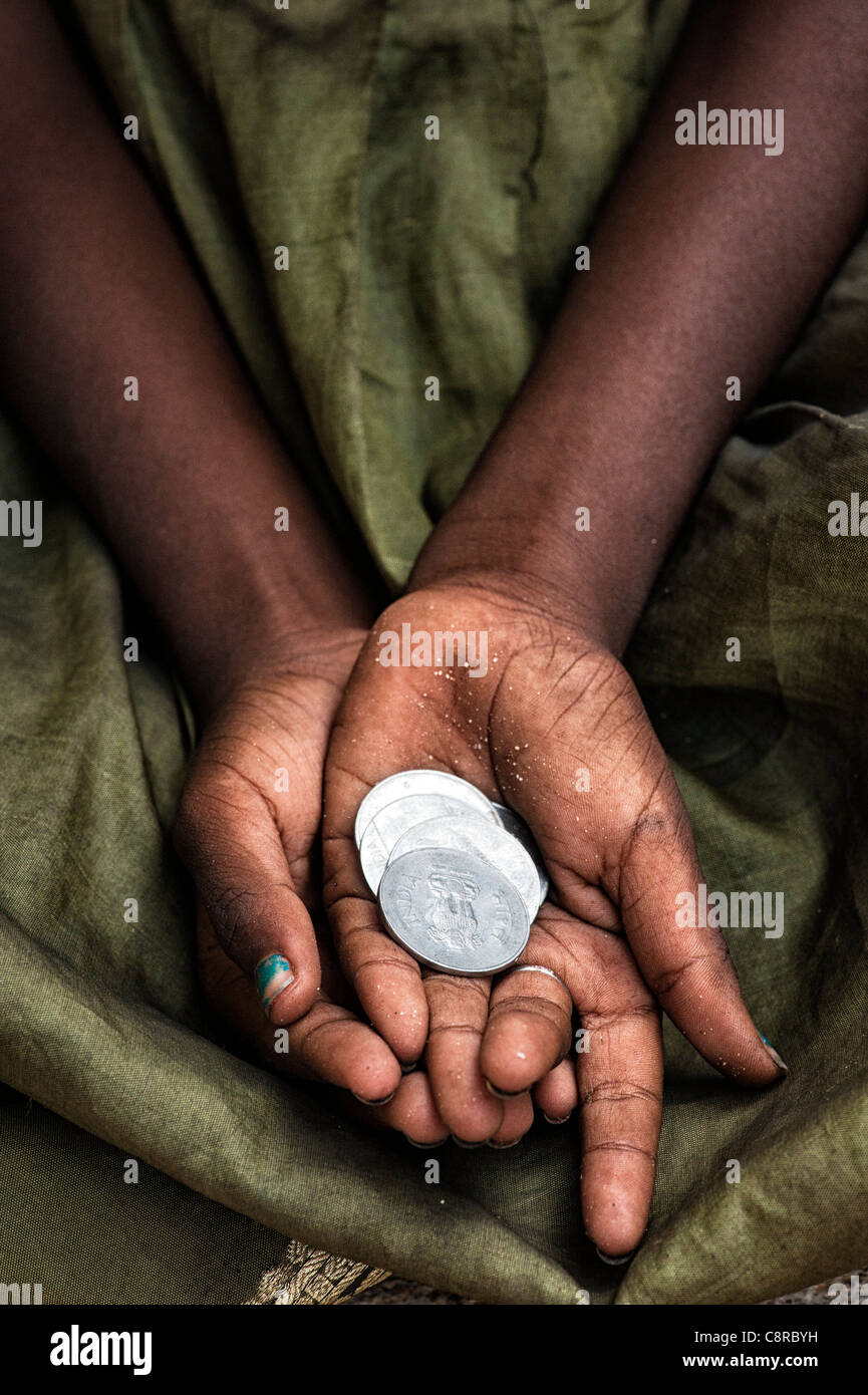 Indische Straße Mädchen betteln um Geld mit Rupie-Münzen in der Hand. Stockfoto