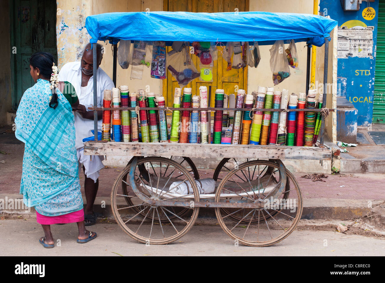 Indischer Mann Armreifen aus einem Holzkarren auf einer indischen Straße zu verkaufen. Puttaparthi, Andhra Pradesh, Indien Stockfoto