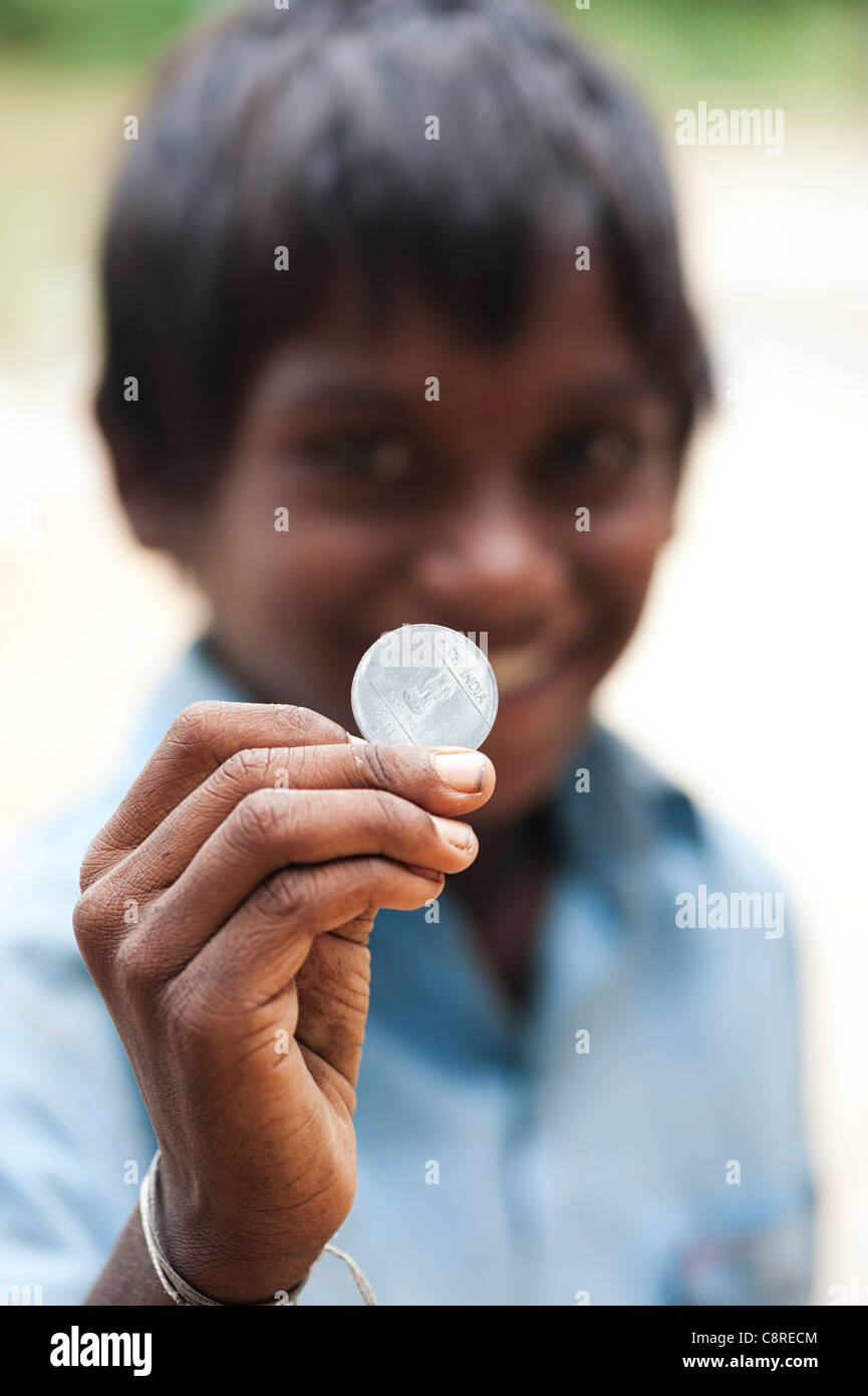 Indische Straße junge eine Rupie-Münze in der Hand halten. Andhra Pradesh, Indien. Selektiven Fokus. Stockfoto