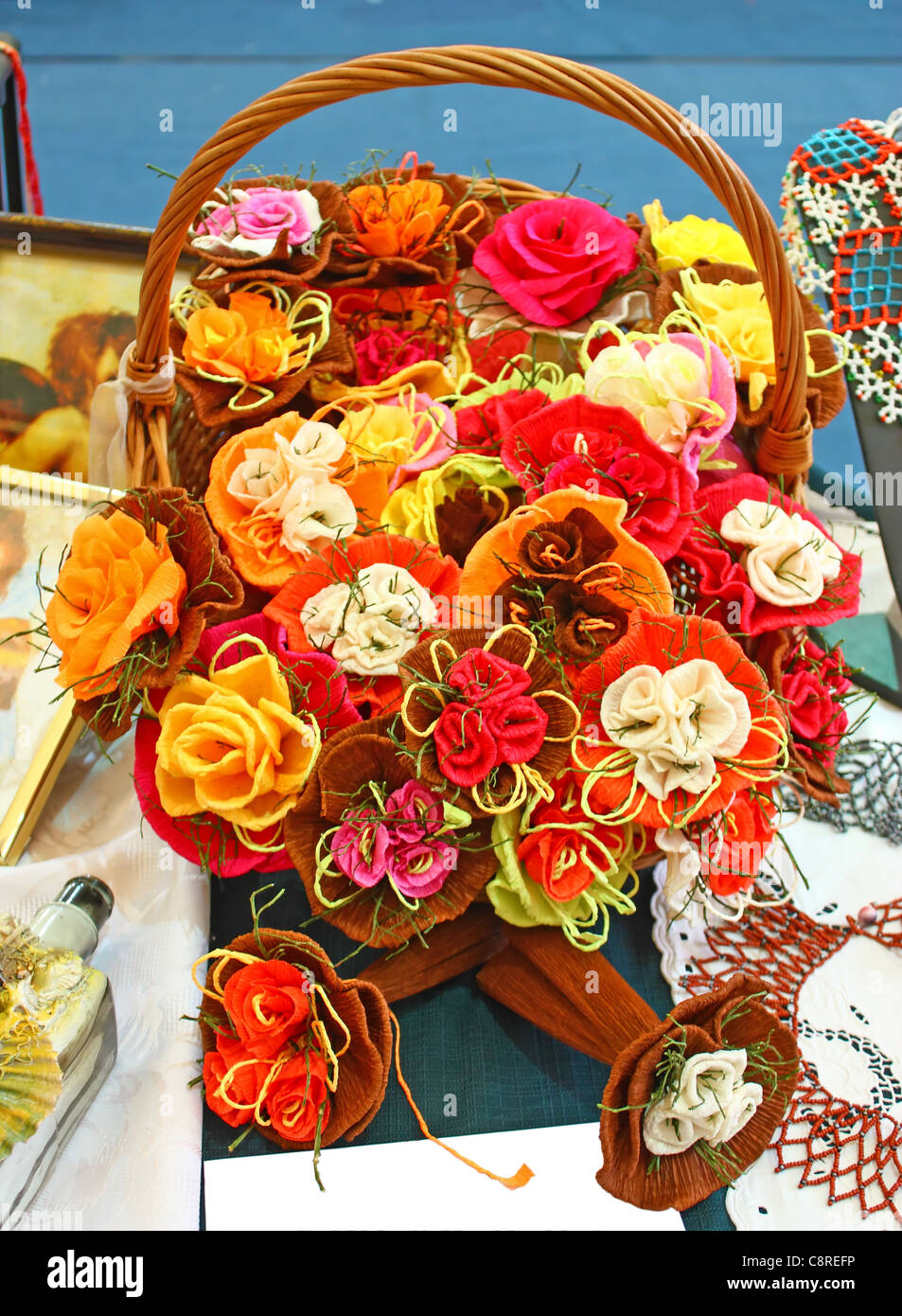 Korb voller künstlich Blumen aus Krepp-Papier Stockfoto