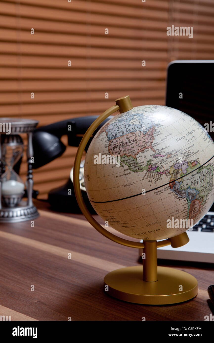 Globus mit Laptop, Timers Glas und Telefon Stockfoto