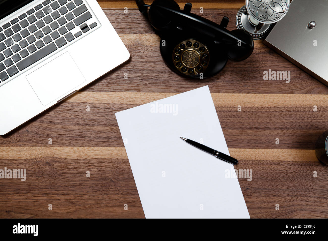 Laptop mit Papieren, Timer Glas und Telefon Stockfoto