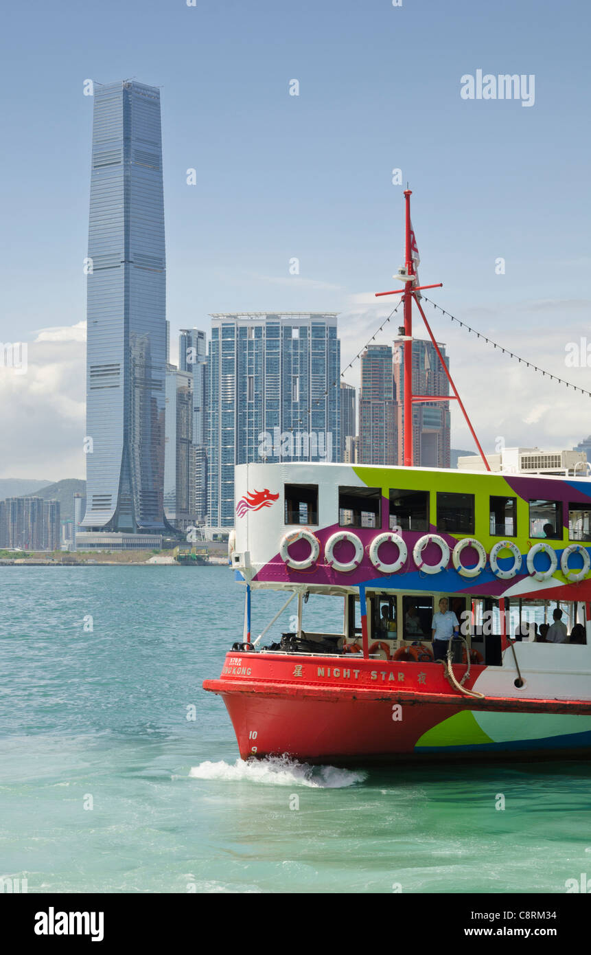 Ein Star Ferry im Victoria Harbour mit der Hong Kong Waterfront Entwicklung vom Union Square im Hintergrund Stockfoto