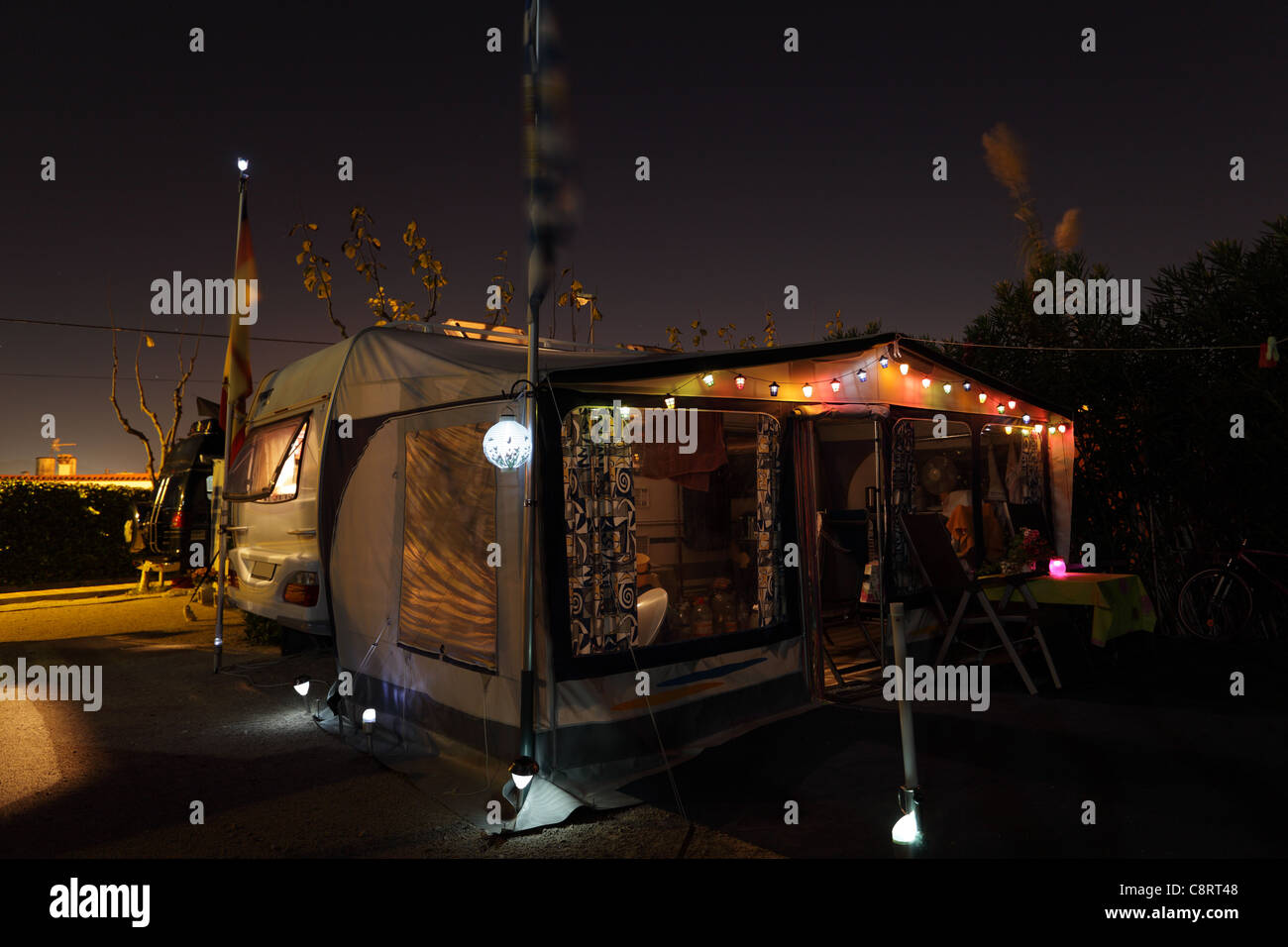 Wohnwagen auf Campingplatz abends beleuchtet Stockfoto
