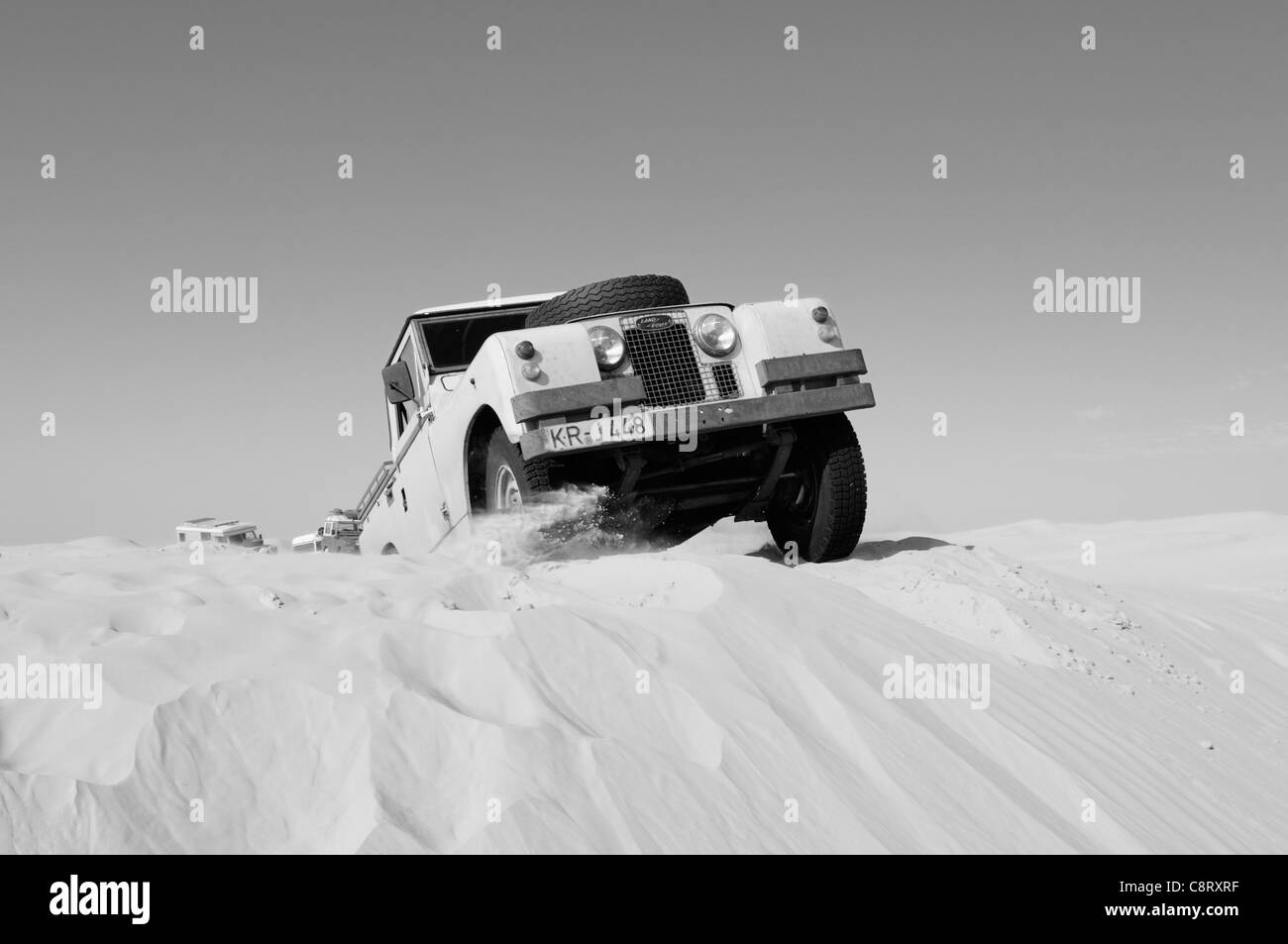 Afrika, Tunesien, nr. Tembaine. Wüste Reisende fahren seine 1964 Land Rover Serie 2a LKW-Kabine durch eine Sandfield nah an... Stockfoto