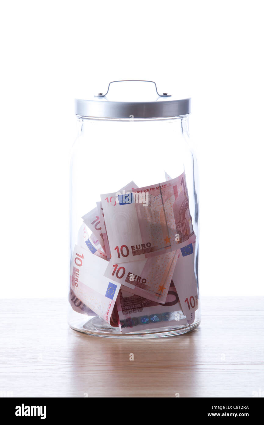 Glas gefüllt mit europäischen Union Geldscheine vor weißem Hintergrund Stockfoto