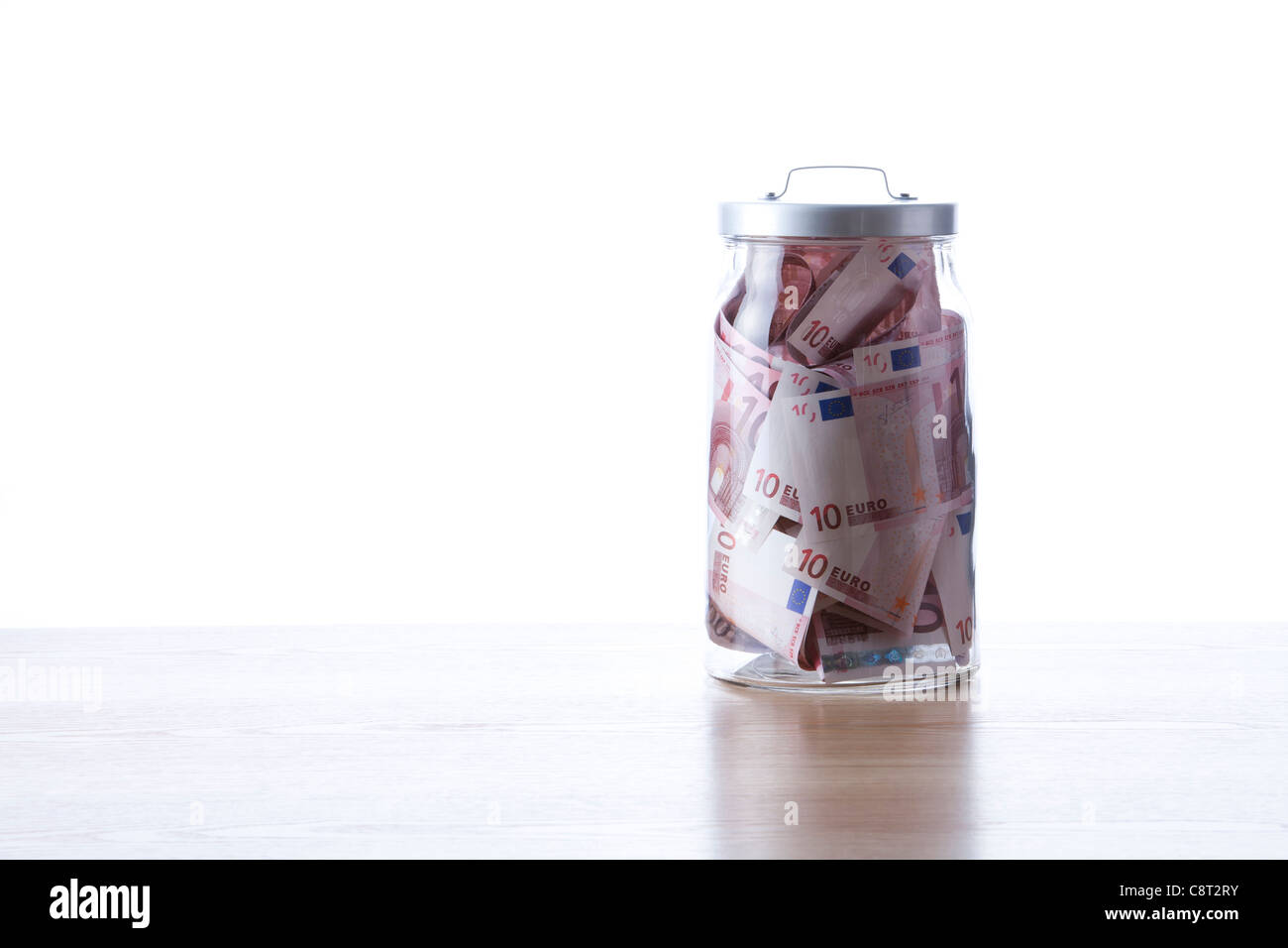 EU-Währung innerhalb des Glas vor weißem Hintergrund Stockfoto