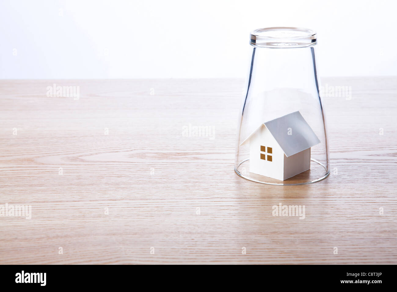 Glas auf dem Kopf stehend mit Modell zu Hause drin Stockfoto