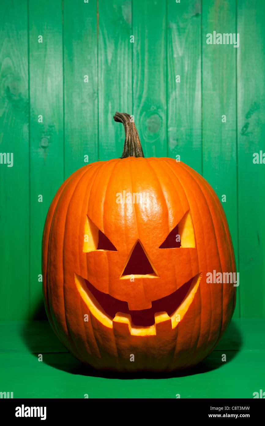 Halloween-Kürbis vorne auf grünem Hintergrund Stockfoto