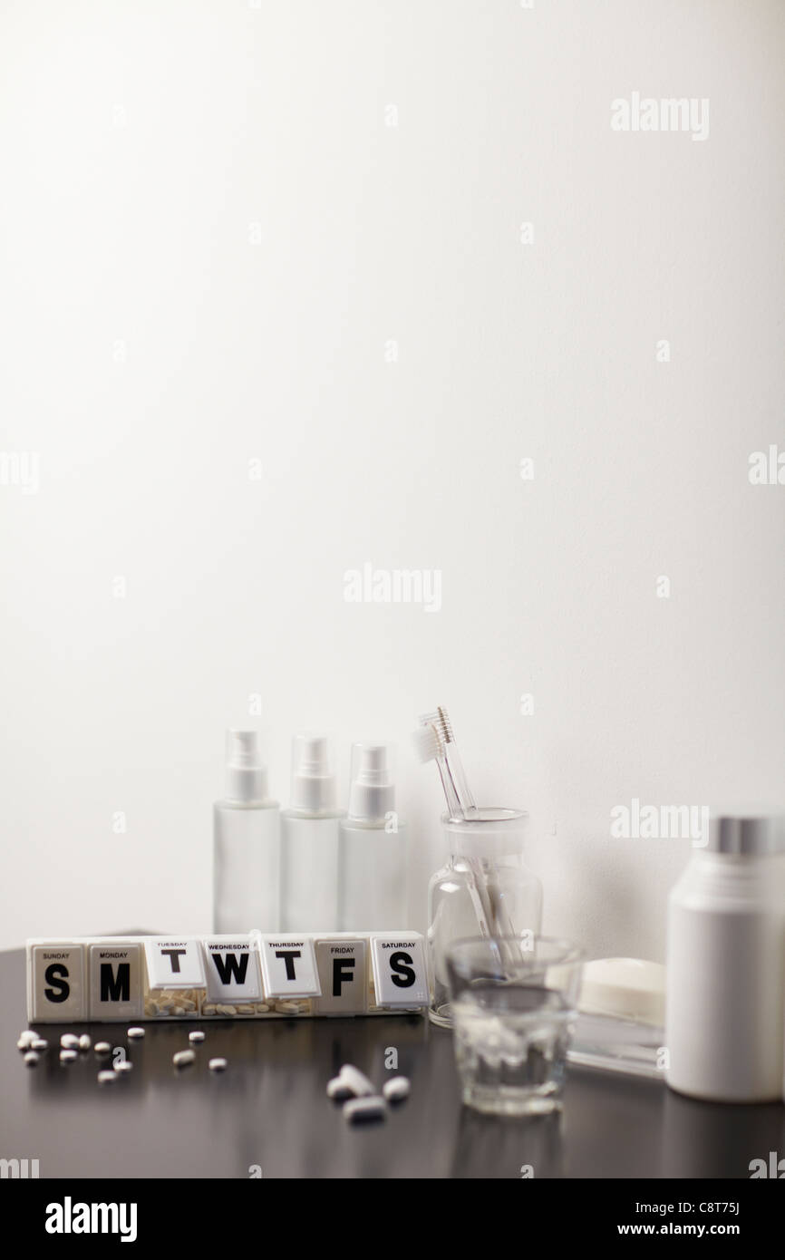 Medikamente mit Wochenplan und Flaschen vor weißem Hintergrund Stockfoto