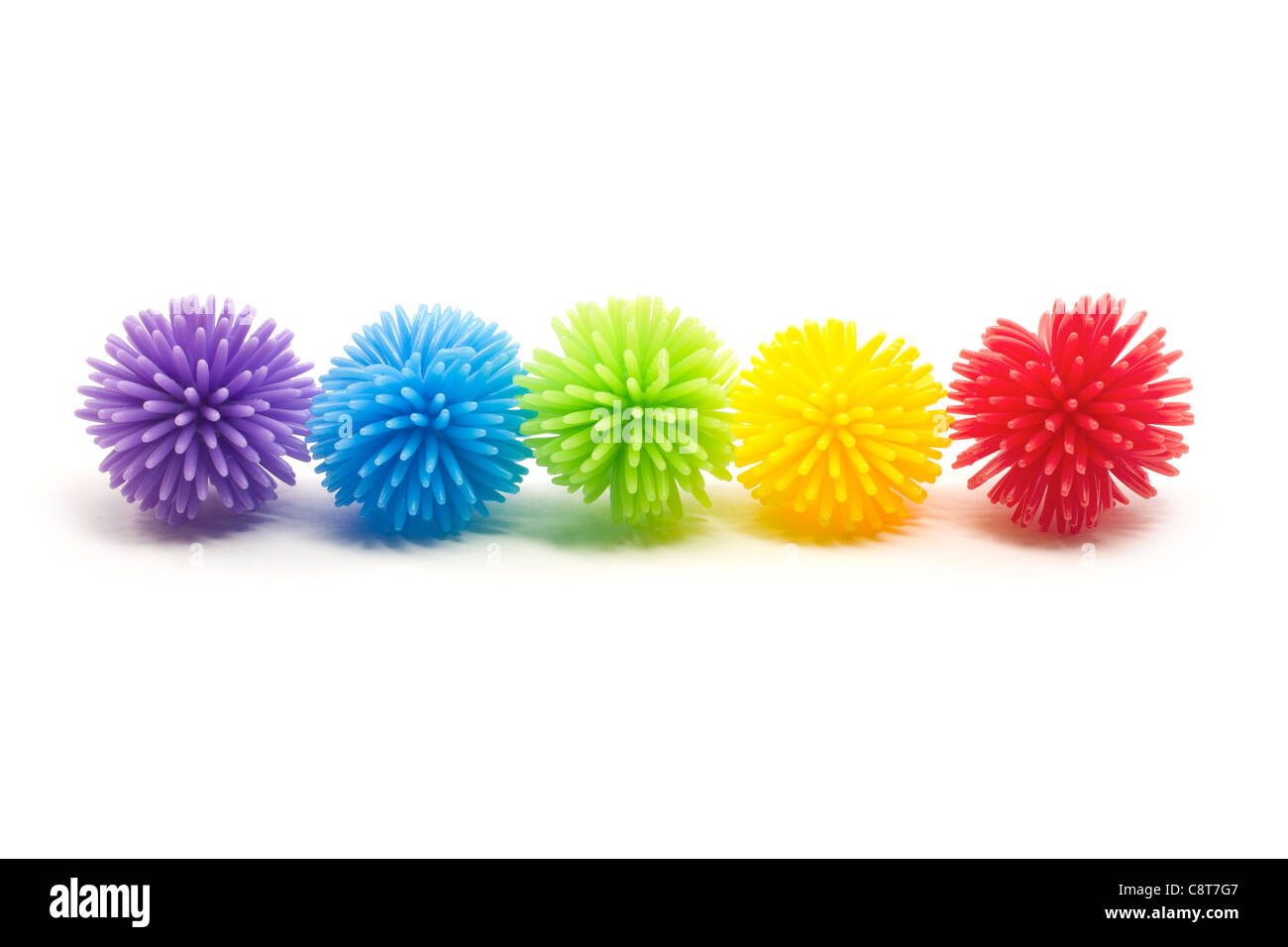 Fünf bunten Koosh Stress Kugeln in einer Linie. Farben sind violett, blau, grün, gelb und rot. Stockfoto