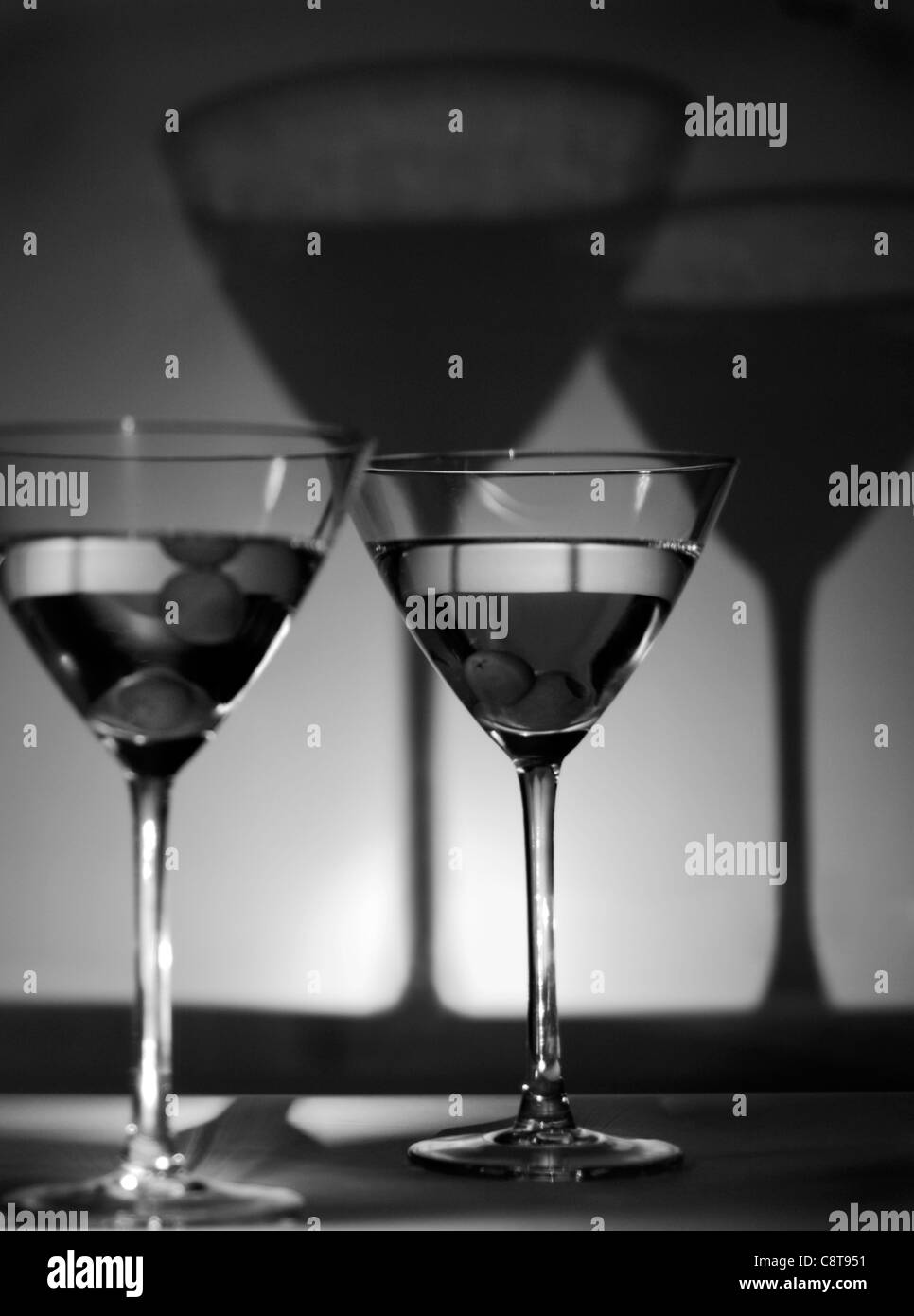 Martini-Gläser mit Oliven, Schatten, schwarz und weiß Stockfoto