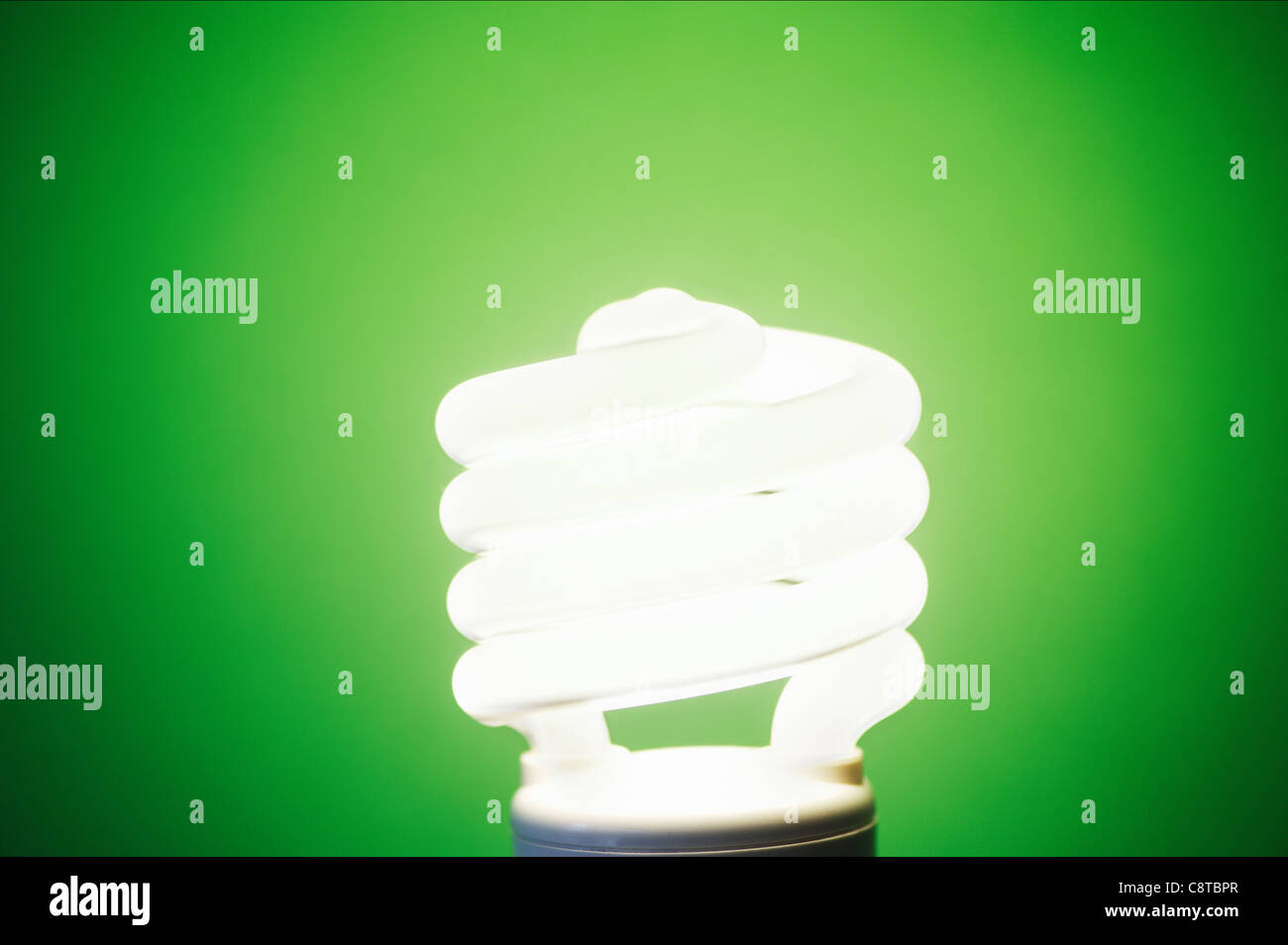 Studioaufnahme von Energie effiziente Glühbirne auf grünem Hintergrund Stockfoto