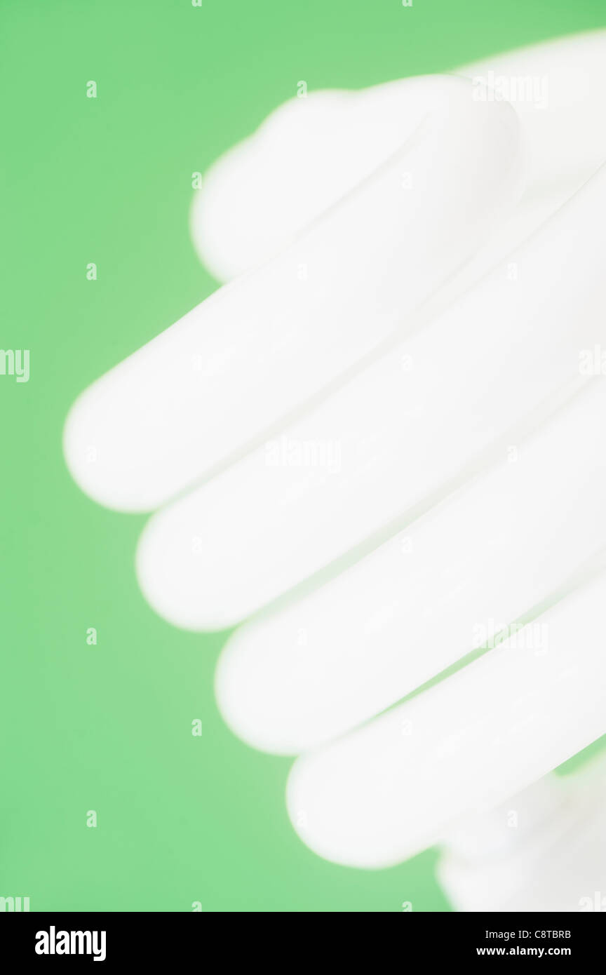 Studioaufnahme von Energie effiziente Glühbirne auf grünem Hintergrund Stockfoto