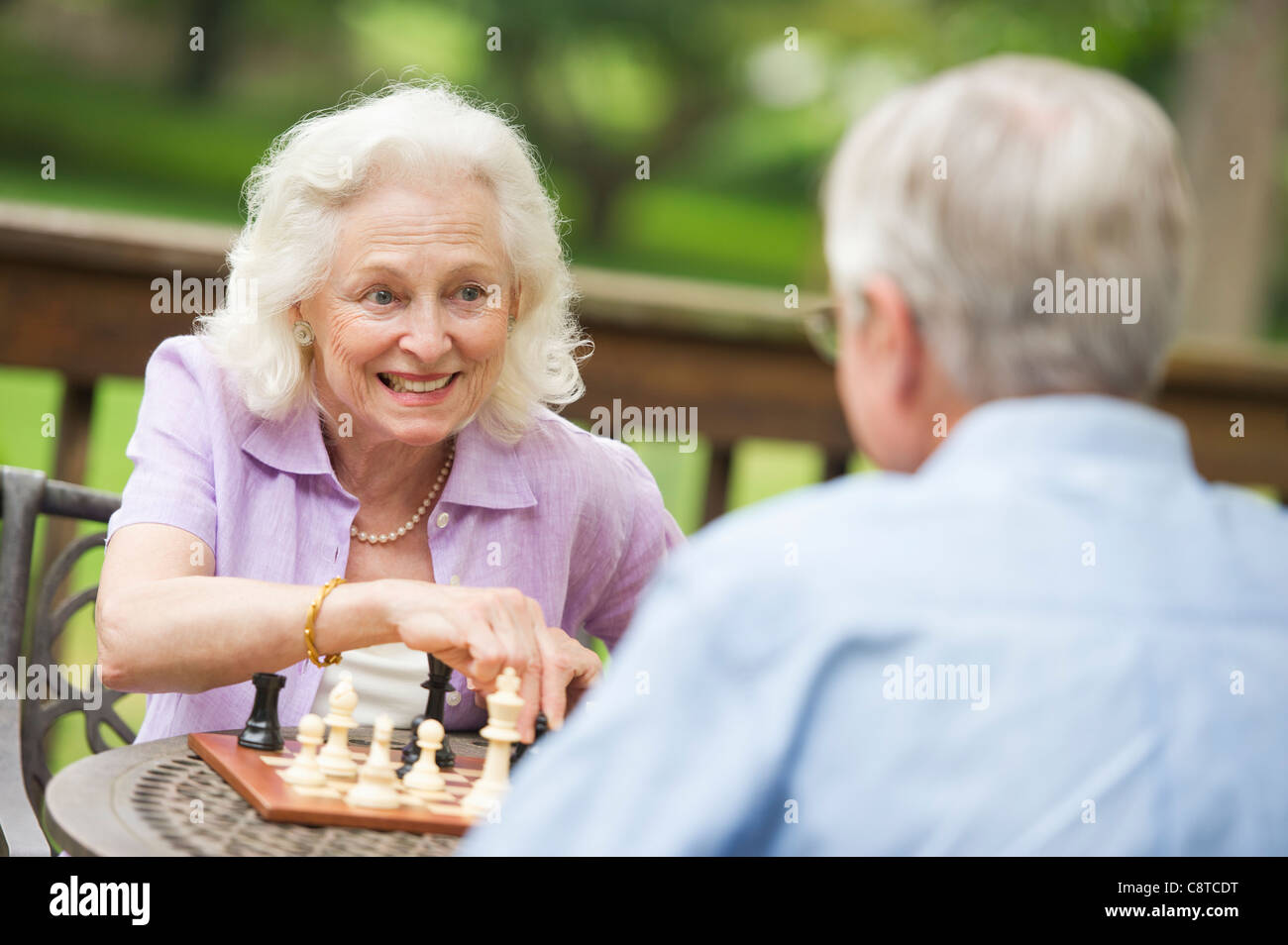 USA, New York State, Old Westbury Senioren spielen Schach auf Veranda Stockfoto