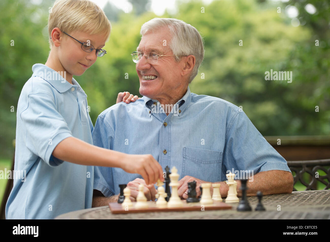USA, New York State, Old Westbury, Großvater und Enkel spielt Schach auf Veranda Stockfoto