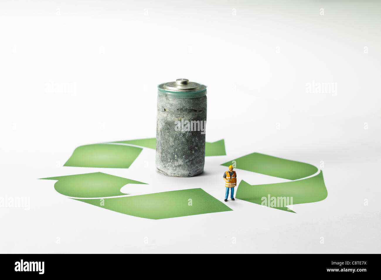 Rostige Batterie mit kleine Figur und recycling-Symbol auf weißem Hintergrund Stockfoto