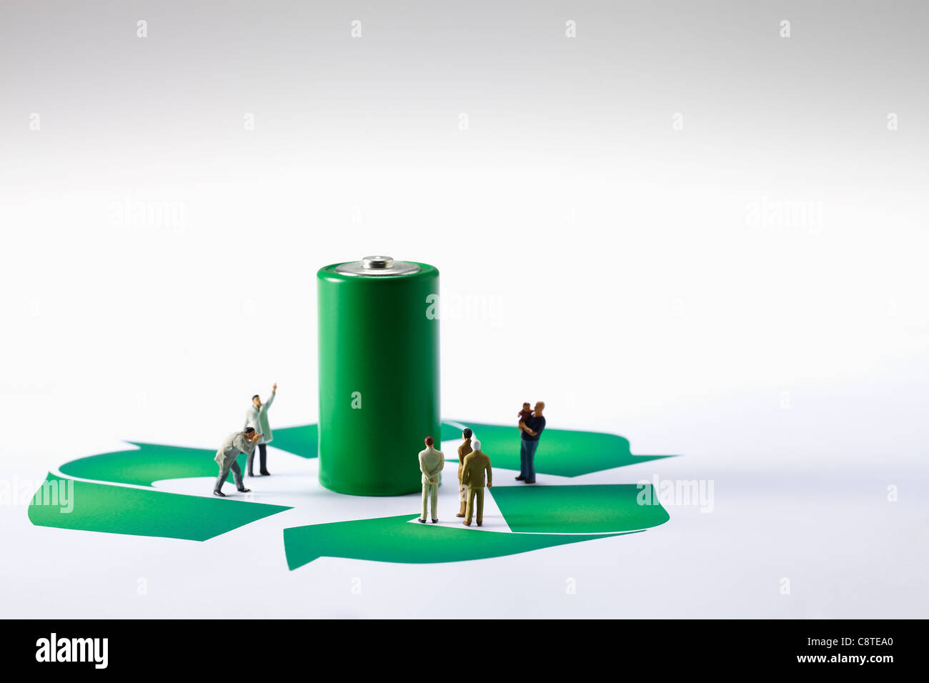 Grüne Batterie mit kleinen Figürchen und recycling-Symbol auf weißem Hintergrund Stockfoto